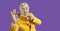 Portrait of funny crazy angry senior casino gambler in yellow suit holding poker chip