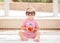 Portrait of funny cute white Caucasian smiling baby girl wearing large sunglasses sitting on floor in swimming pool