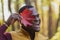 Portrait of funny face emotion african american man covering his face with autumn maple leaf. Autumn nature. Seasonal