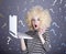 Portrait of funny girl in blonde wig with laptop.