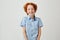 Portrait of funny little boy with red hair and freckles smiling brightfully, looking in camera, posing for family photo