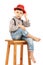 Portrait of a funny little boy sitting on a high stool in a red