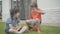 Portrait of funny little boy talking with friend or brother sitting on basketball ball. Friendly Caucasian siblings or