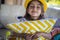 Portrait of funny little girl in summer yellow straw hat hugging ornamental pillow happy childhood