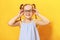 Portrait of a funny little girl on a yellow background. Preschool child straightens glasses