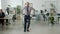 Portrait of funny man dancing in office while businesspeople working in background
