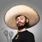 Portrait of funny man in Mexican sombrero on gray background