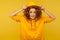 Portrait of funny positive girl with curly hair wearing urban style hoodie, putting on hood and smiling