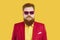 Portrait of funny serious bearded chubby man in red suit, yellow shirt and funky sunglasses