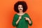 Portrait of funny serious woman with Afro hairstyle wearing green casual style sweater pointing at