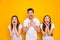 Portrait of funny three people shouting yelling wearing white t-shirt isolated over yellow background