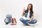 Portrait of funny woman student in denim clothes showing OK sign, blinking sitting near globe, backpack, school books