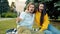 Portrait of funny young couple girl and guy taking selfie outdoors in city park