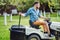 Portrait of gardener using a lawn mowing tractor for cutting grass