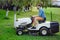 Portrait of gardener using a lawn mowing tractor for cutting grass