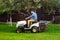 Portrait of gardener using a lawn mowing tractor for cutting grass