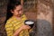 Portrait gardener young asea woman look at a full cup of raw para rubber milk of tree in plantation rubber tapping form Thailand,