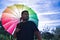 Portrait of gay boy with open backlit rainbow umbrella over shoulder. Concept gay, lgbtq+, inclusion, lesbian, lgbtq