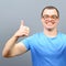 Portrait of a geek showing thumbs up against gray background