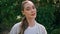 Portrait gentle woman posing at forest greenery. Serene girl sitting green park