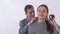 Portrait of genuine man in gray suit puts a pendant on the neck of a girl close up. Shooting in the studio on a white