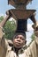 Portrait Ghanaian boy lugging stoves on the head