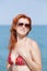 Portrait of ginger girl in sunglasses at the sea