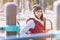 Portrait of a girl athlete in a hat with gloves and a warm vest next to a workout playground outdoors in the winter on a