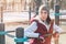 Portrait of a girl athlete in a hat with gloves and a warm vest next to a workout playground outdoors in the winter on a