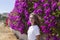 Portrait of a girl on a background of bougainvillea flowers in a park. The concept of youth and natural beauty