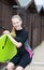 Portrait Of Girl By Beach Huts In Wetsuit Holding Bodyboard