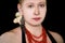 Portrait of girl with Boa constrictor albino snake on head. Woman with jewelry, necklace and earring  is posing in front of camera