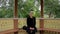 Portrait of a girl with braid dressed in black sitting in the gazebo in summer