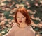 Portrait of a girl with bright red hair. Stern face.