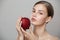 Portrait of a girl with clean skin holding an apple. Organic cosmetics concept.
