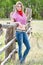 Portrait of the girl - cowboy at an old fence