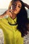 Portrait of girl with dark hair in bright shirt posing on beach