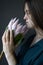 Portrait of a girl with dark hair holds a pink huge protea, selective focus