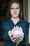 Portrait of a girl with dark hair holds a pink huge protea, selective focus