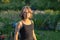 Portrait of a girl with glasses in black clothes in a blooming evening summer garden