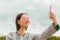 Portrait of a girl in glasses. does selfie on the phone. blue sky background