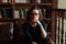 Portrait of a girl in glasses sitting in a library