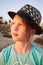 Portrait of girl with golden hair close-up in a black hat. A girl admires the sunset. Las salinas, Torrevieja, Spain