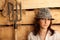 Portrait of girl in hat in hayloft with pitchfork