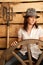 Portrait of girl in hat in hayloft with pitchfork