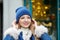 Portrait of a girl in a hat and scarf, a walk through the Christmas city, a smile on her face, cool weather, a fascinating look