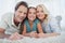 Portrait of a girl and her parents lying on a carpet