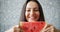 Portrait of girl holding water melon smiling hiding face on brick background