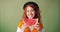 Portrait of girl holding watermelon smiling hiding face on green background