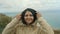 Portrait of a girl in a hood looking at the camera on the background of the sea